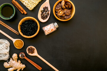 Chinese and Japanese food cooking with ginger, spices and noodles on black background top view mock-up