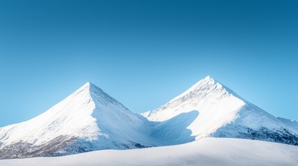 Snow-capped mountains under a clear blue sky, winter weather, cold and majestic