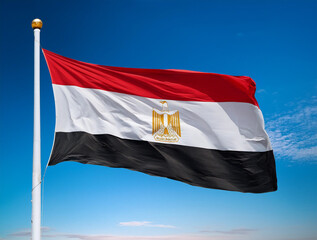 The flag of Egypt fluttering in the wind with blue sky background