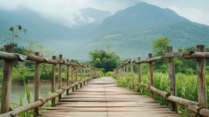 Obraz premium A scenic view of a serene wooden bridge leading into lush, misty mountains, inviting a feeling of tranquil exploration and connection with nature.