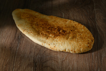Appetizing Pita on a wooden background, side view, selective focus.