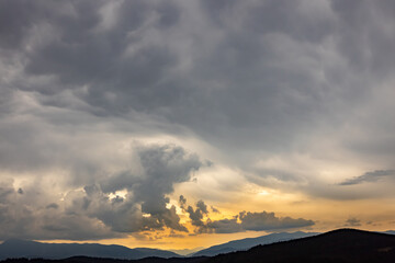Sunrise in the mountains, panoramic view, mountain peaks with clouds.