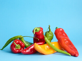 Assortment of long sweet peppers over blue background