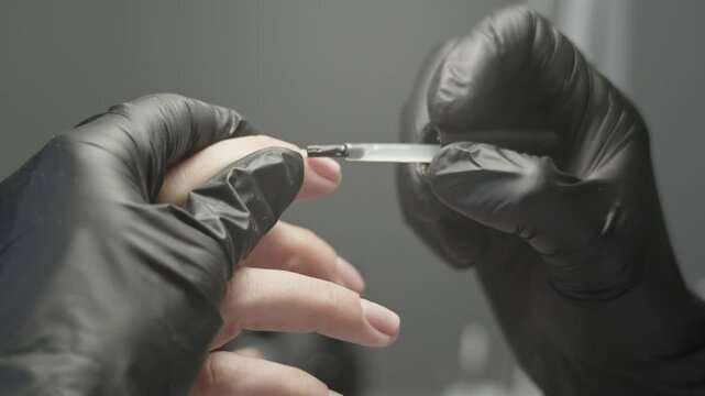 Woman manicure master makes gel coating varnish in the salon. The concept of beauty professional nail care