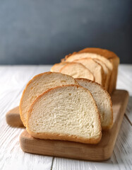 Delicious bread slices on white wooden table, closeup