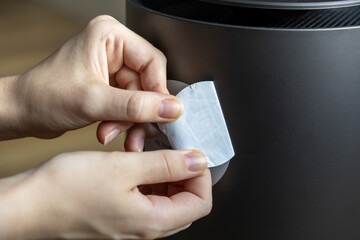 A woman peels off the sticker.