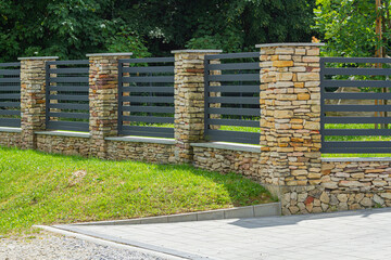 Ogrodzenie z murkiem z kamienia i stalowymi przęsłami malowanymi proszkowo   Fence with a Stone Wall and Steel Powder-Coated Panels © Adrian White