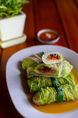 Close-up the steamed cabbage with minced meat roll serving on the white plate. Healthy recipe, low calorie and diet food