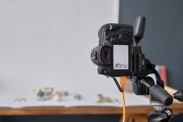 Background image of professional DSLR camera mounted on tripod in photographers studio during commercial product photoshoot copy space