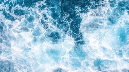 Fototapeta premium Aerial view of turbulent ocean waves and white foam, capturing the power and movement of the sea in vivid blue tones.
