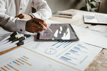 Businessman analyzing financial data with fine art fonts, reflecting investment strategies, market trends and economic growth, with an emphasis on wealth management, income and risk planning.” © Witoon