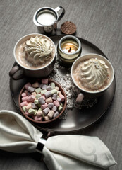 Two cups of cappuccino with creamy meringue and marshmallow .