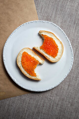 Slices of bread with butter and red caviar.