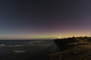 Night scene, view from the Paldiski sea cliff, starry sky and faint northern lights in August.