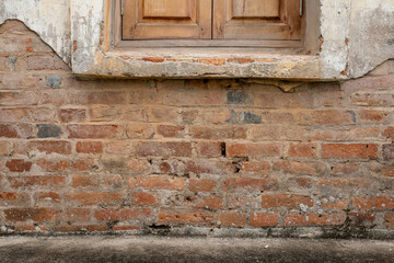 Old brick wall with crumbling cement revealing the Antique brickwork.