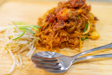 Thai food, Pad Thai, Noodle with soft shell crab with bean sprouts and spring onions on wooden plate