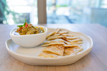 Crispy roti served with green curry with chicken on wooden table