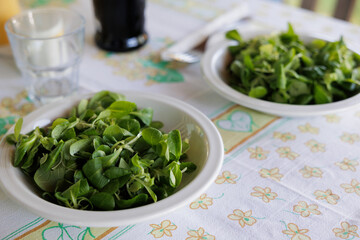 piatti con foglie di insalata verde su un tavolo apparecchiato per il pranzo