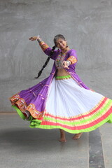 girl wearing chaniya choli, banjara shrug and playing garba in navratri. skirt full flare is rotating in the air round. wearing oxidized jewellery and long braid. Indian traditional garba dancer