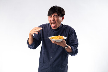 An Asian man in a dark shirt reacts dramatically to spicy noodles, his face expressing surprise and...
