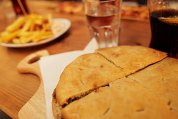 dettagli macro di un panino caldo di forma rotondo, ripieno con formaggio e prosciutto,...