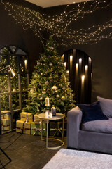 Christmas interior with a beautiful Christmas tree, sofa, light bulbs and dark background.