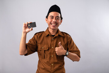 An Asian man in a brown uniform and a traditional black cap gives a thumbs-up while holding a business card in his other hand, The simple white background