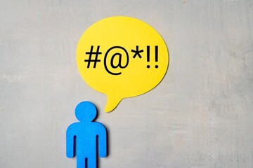 Blue figure with a yellow speech bubble containing symbols on a grey background. Profanity, foul...
