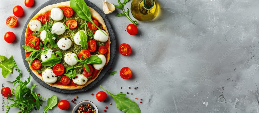 Poster top down view of roman pizza topped with mozzarella tomatoes pesto and fresh arugula on a gray backd