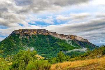 View to a mountain ridge in the French Maritime Alps with haze and heavy cloud cover.