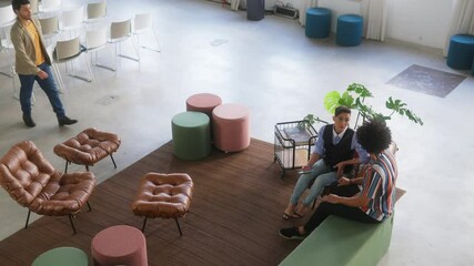 High angle of Confident business colleagues greeting business client or colleague on sofa of business lounge.  