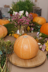 Flower arrangement in a pumpkin, autumn interior decor. Creating handmade autumn decor.