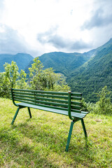 Green bench overlooking Pyrenean mountains