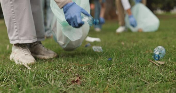 Garbage, cleaning and volunteer in outdoor park for community service, waste or trash pollution. Charity, bags and ngo worker tidying grass of dirt for eco friendly outreach project in environment.