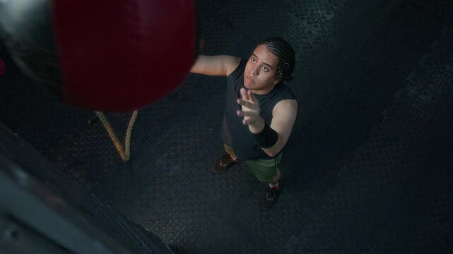 High angle view of young male athlete practicing wall ball squats during workout in fitness gym