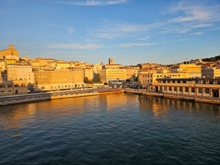 Obraz premium Golden sunset over the port in Ancona, Italy, highlighting historic architecture and calm waters during evening