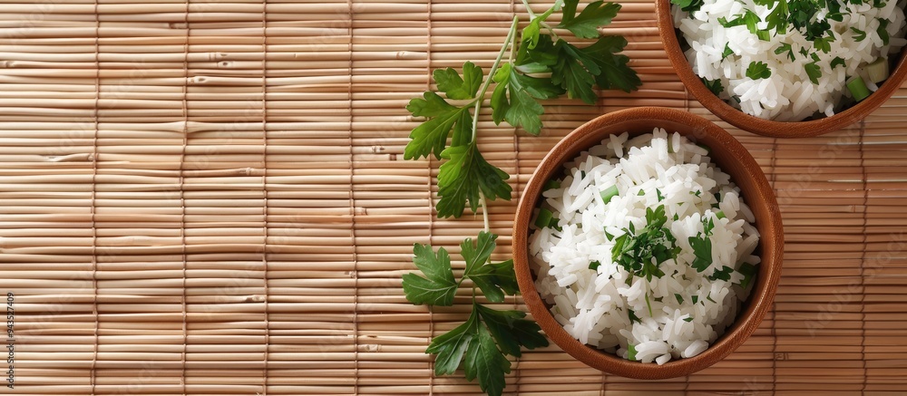 Aufkleber Top view of appetizing boiled rice bowls garnished with parsley on a bamboo mat suitable for adding text in the copy space image