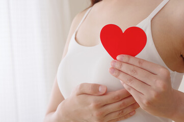 胸の前でハートのオブジェを持つ女性