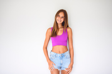 portrait of a 14 years old teen girl close to a white wall with colored shirt