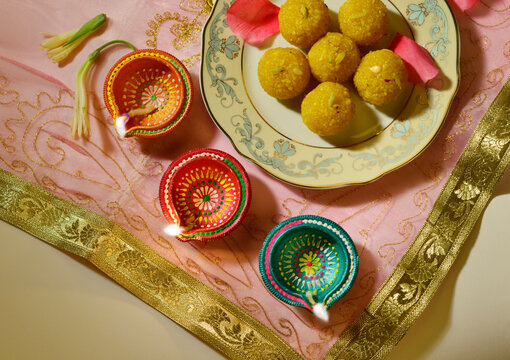 Top view of of delicious Bundi Laddu placed along with row of Diwali diyas. Traditional food or sweet is an integral part of Indian festivals or an auspicious accasions. 