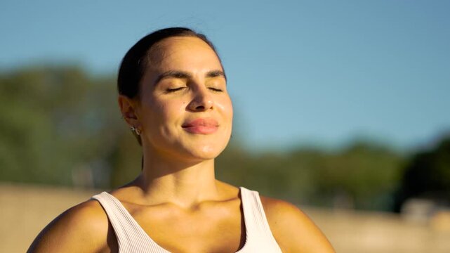 Composed athlete inhales deeply, basking in the golden glow of the afternoon sun post-training. A detailed portrait capturing a moment of respite and refreshment during a rigorous fitness routine