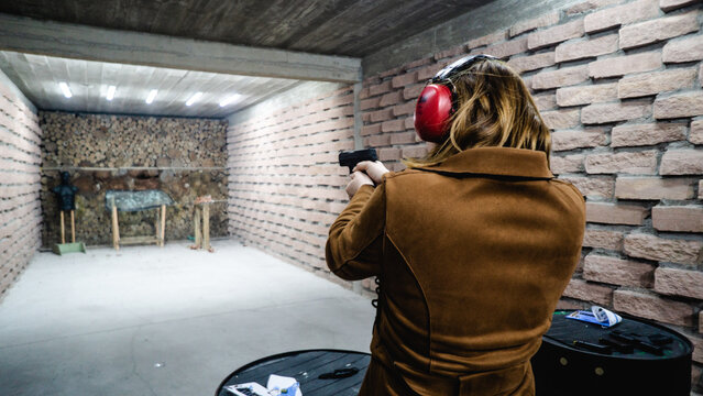 mulher com arma disparando arma de fogo