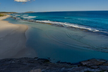 beach in the morning with a mirror-like rock pool