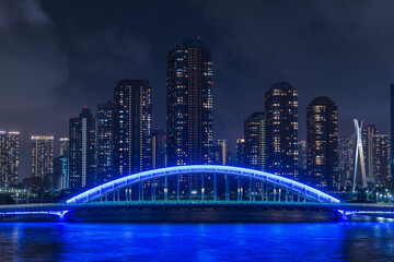 Obraz premium 日本 東京都中央区の隅田川大橋から眺める月島のマンション群の夜景とライトアップされた永代橋