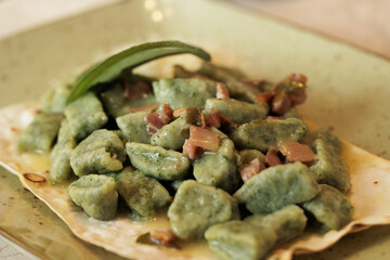 piatto con gnocchi alle verdure fatti in casa e pezzetti di pancetta