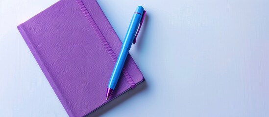 Purple notebook and blue pen viewed from above on a white background making it suitable for school or office themed wallpapers with a flat lay composition and ample copy space image