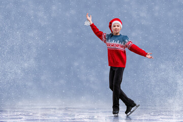 Boy figure skater in Santa Claus hat skating on ice. © Maria Moroz