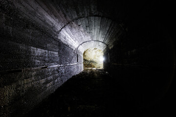 interni in cemento e in roccia di una grande stanza di un antico bunker militare abbandonato della seconda guerra mondiale illuminato in controluce