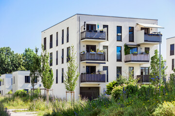 Residential Building with Modern Balcony Terrace Outside, White Facade, Stylish Exterior Design, Flat Roof and Green Garden Landscaping. Modern Low-rise Apartment Building  in Germany Europe. 
