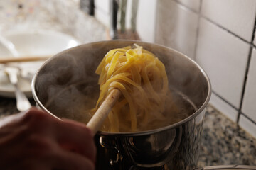 scolare la pasta dalla pentola in cucina